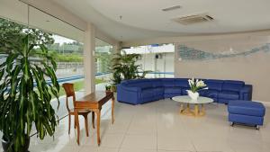 哥打京那巴鲁欧胜娜酒店 的客厅配有蓝色的沙发和桌子