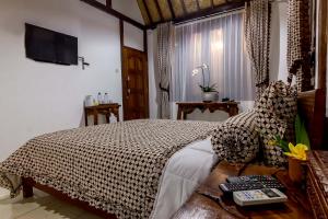 婆罗浮屠The Omah Borobudur的卧室配有一张床,墙上配有电视。