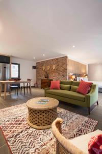 斯泰伦博斯Mont Angelis的客厅配有绿色沙发和桌子