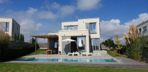 洛泽内茨Villa Cape Vergoti的一座白色的房子,前面设有一个游泳池