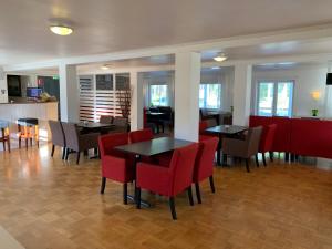 布达Böda Hotell的用餐室配有桌子和红色椅子