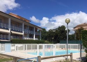 安德诺莱斯贝恩Appart Les Goélands piscine et jardin的大楼前设有游泳池的酒店