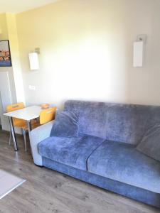 图卢兹图卢兹圣​​米歇尔拉格朗日公寓式酒店*** 的客厅配有一张蓝色的沙发,配有一张桌子