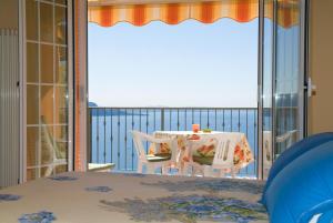 加尔多内-里维耶拉Villa Panorama Residence的阳台配有桌子,享有海景。