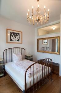 德累斯顿Sachsenperle的一间卧室配有一张带吊灯和镜子的床