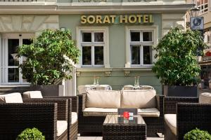科特布斯科特布斯索拉特酒店的酒店前方的餐厅设有柳条椅和桌子