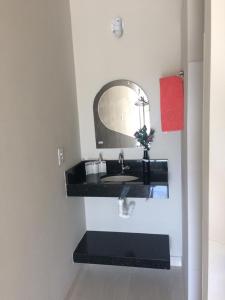 卡皮托利乌Suíte Triplex的一间带水槽和镜子的浴室