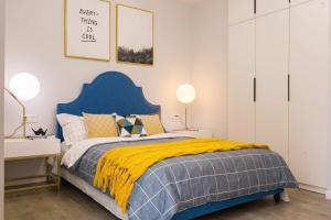 武汉武汉市武昌区·群星城·路客精品民宿·00121920的一间卧室配有一张蓝色的床和黄色的毯子