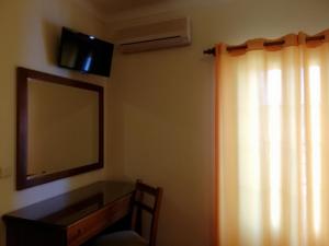 奥德米拉Residencial Idalio的一间卧室配有镜子、梳妆台和窗户