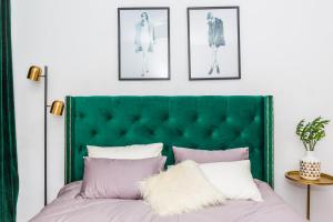 青岛青岛市市南区·青岛栈桥·路客精品公寓·00133930的卧室内的绿色床头板,配有粉色和白色枕头