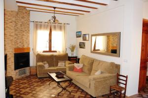 CarcelénCasa Rural Los Montones的带沙发和壁炉的客厅