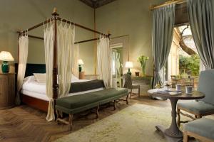佛罗伦萨加木格里诺侯爵宫依波娜酒店的一间卧室配有天蓬床和桌椅