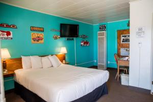 塞利格曼Historic Route 66 Motel的卧室配有一张床,墙上配有电视。