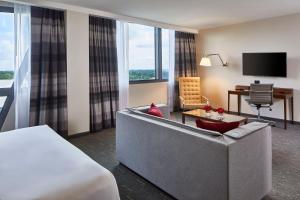 亚特兰大Kimpton Overland Hotel - Atlanta Airport, an IHG Hotel的酒店客房配有床、沙发和电视。