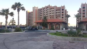 佩尼亚斯科港Sonoran Sun Resort的停车场,有楼房和棕榈树