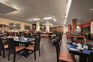 丹戎ASTON Tanjung City Hotel的餐厅内带桌椅的用餐室