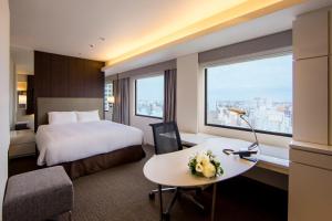 川崎川崎日航酒店的配有一张床、一张书桌和一扇窗户的酒店客房