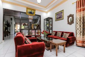 美娜多RedDoorz near Sam Ratulangi Airport Manado的客厅配有红色椅子和桌子