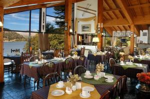 圣卡洛斯-德巴里洛切Hosteria El Condado by Nordic的一间设有桌椅并享有水景的餐厅