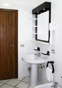 帕劳波尔图曼努公寓酒店的一间带水槽、镜子和卫生间的浴室