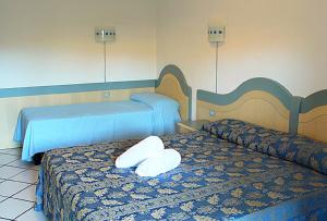 帕劳波尔图曼努公寓酒店的酒店的客房 - 带2张床和白色枕头