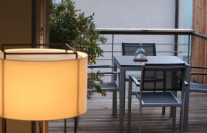 伊普霍芬盖斯汀豪斯维根酒店的阳台配有桌椅和台灯。