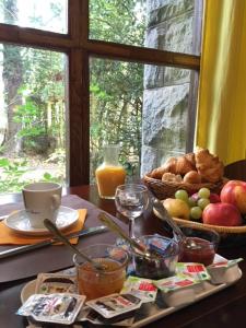 Montfaucon-en-Velay普拉坦斯酒店餐厅的一张桌子,上面放着一盘食物和一篮水果