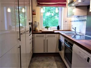 苏尔Ferienwohnung Ringbergblick的厨房配有白色橱柜、水槽和窗户。