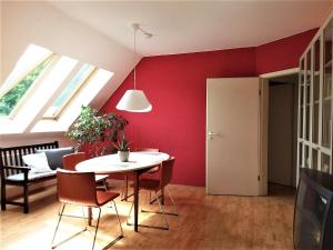 苏尔Ferienwohnung Ringbergblick的一间拥有红色墙壁和桌椅的用餐室