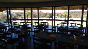 科斯塔里卡Ives Hotel的餐厅设有桌椅和大窗户。