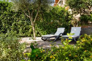 维克艾库塞Villa Russo的花园内提供两把白色椅子和一张桌子