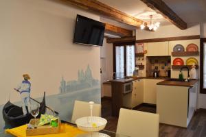 威尼斯CA' DE' KOCAI的厨房配有桌子,墙上配有电视。