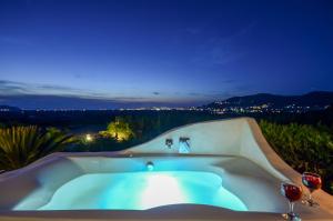 Glinado NaxosNaxos Villa Bella Vista的浴缸及两杯葡萄酒