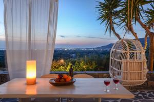 Glinado NaxosNaxos Villa Bella Vista的一张桌子,上面放着两杯葡萄酒和蜡烛