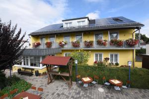 因戈尔施塔特Hotel Hecht Garni的一座黄色房子,上面有太阳能电池板