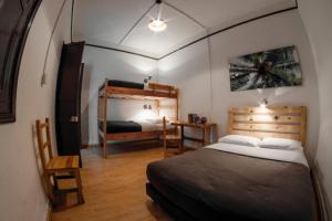波哥大探索酒店的一间卧室配有一张大床和一张双层床。