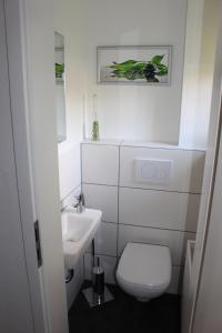 莱比锡Villa LE的白色的浴室设有卫生间和水槽。