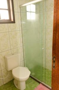 佩尼多Chalé saí azul的一间带卫生间和玻璃淋浴间的浴室