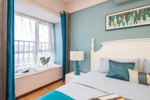 郑州郑州市金水区·北三环国贸中心·路客精品公寓·00163170的一间拥有蓝色墙壁的卧室、一张床和窗户