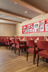 塔巴尔茨AKZENT Hotel Zur Post的一间带长桌和红色椅子的用餐室