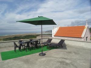 卡尔瓦略A casa de Chuco的屋顶上配有绿伞的桌椅