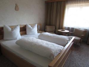 伊姆斯特Ferienhaus Tschenett的酒店客房配有带白色床单和枕头的床。