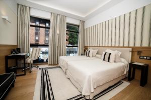 桑坦德萨尔大酒店的卧室配有一张白色大床和一张书桌