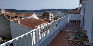 卡马里尼亚斯A CARAMIÑA的阳台设有白色栏杆和木板凳