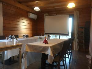 蒙代列赫瓦莱里酒店的一间会议室,配有两张桌子和投影屏幕