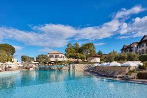 库克里亚Atlantica Aphrodite Hills Hotel的一座带椅子和树木的度假村游泳池