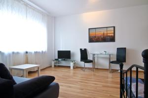 科隆拉赫中央顶级公寓的客厅配有沙发、椅子和桌子