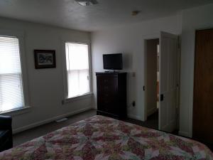盖茨堡Pearl's Place的一间卧室设有一张床、一台电视和窗户。