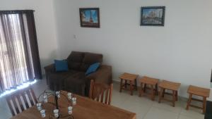 卡皮托利乌Apartamentos Mirante de Escarpas的客厅配有沙发和桌椅
