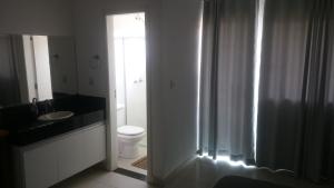 卡皮托利乌Apartamentos Mirante de Escarpas的浴室配有卫生间、盥洗盆和淋浴。